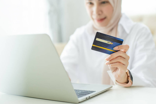 Πιστωτική κάρτα για να πληρώσει, ασιατικές όμορφες μουσουλμάνες γυναίκες κορνάρουν στην πληρωμή και ψώνια σε απευθείας σύνδεση. - Φωτογραφία, εικόνα
