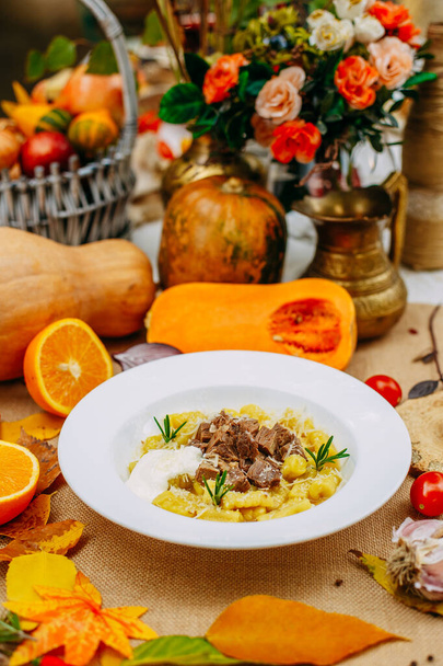 Autumn table setting with pumpkins. Thanksgiving dinner. Sliced cooked dough with meat - Fotografie, Obrázek