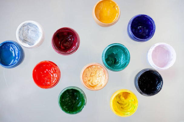 jars of gouache on a glass table indoors - Foto, afbeelding