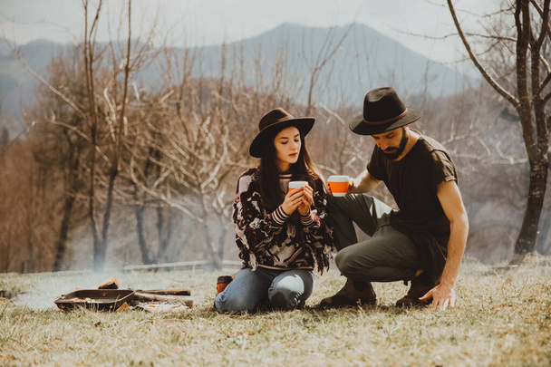 stylish bearded man and young attractive woman took a trip to the mountains - 写真・画像