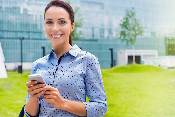 Young attractive businesswoman using smartphone outdoors - Fotoğraf, Görsel