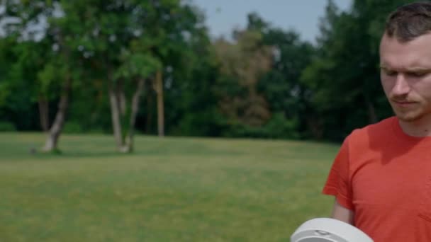 Man in a park in a red T-shirt puts a virtual reality helmet on his head - Filmagem, Vídeo