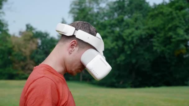Um homem em um capacete realidade virtual abaixa a cabeça para baixo
 - Filmagem, Vídeo