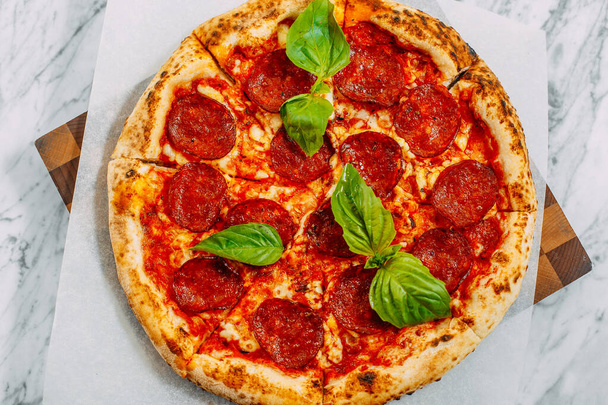 Italian pizza with mozzarella cheese and basil on a marble table - Valokuva, kuva