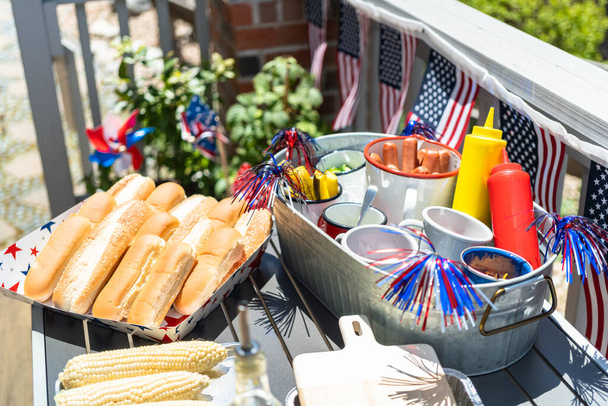 Arka verandada 4 Temmuz kutlamaları için mısır koçanlı sosisli sandviç barı.. - Fotoğraf, Görsel