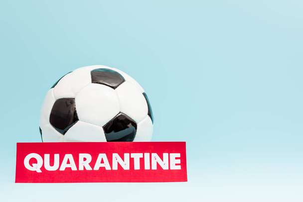 football near paper with quarantine lettering on blue  - Φωτογραφία, εικόνα