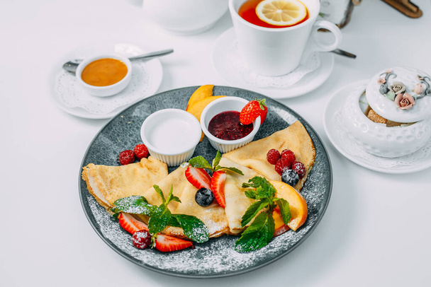 блины с клубникой, малиной и джемом, завтрак, здоровое питание на белом фоне
 - Фото, изображение