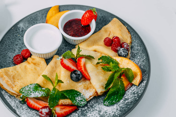 pannukakkuja mansikoilla, vadelmilla ja hillolla, aamiainen, terveellinen ruoka eristetty valkoisella pohjalla
 - Valokuva, kuva