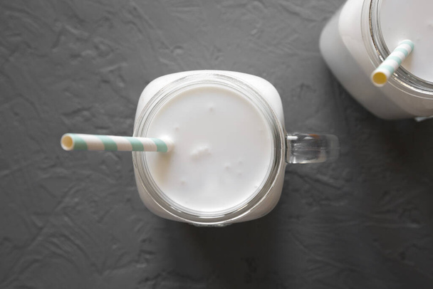 Kokosové mléko ve sklenici na šedém povrchu, pohled shora.  - Fotografie, Obrázek