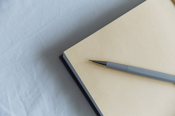 grijze pen op een dagboek op een witte achtergrond - Foto, afbeelding