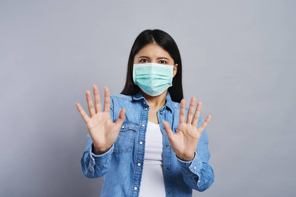 Asustada mujer asiática en máscara quirúrgica
 - Foto, imagen