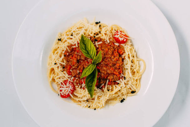 italienische Pasta Bolognese mit Tomaten und Basilikum isoliert auf weißem Hintergrund - Foto, Bild