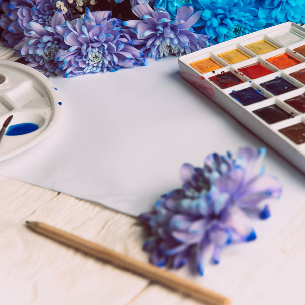 Palette of watercolor paints, brushes and paper for a water color on wooden background, close up. Flat lay, spring background with copy space. - 写真・画像