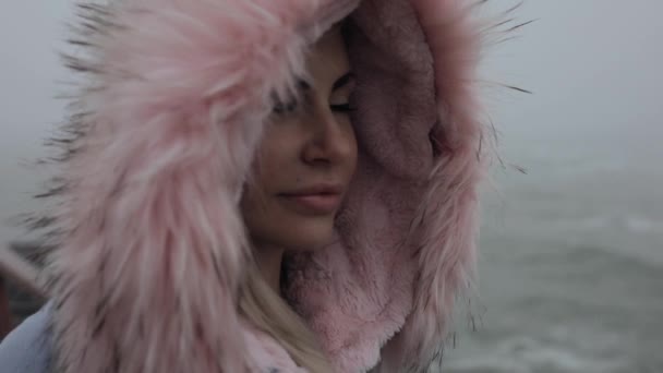 Klid, žena dívající se na mořské vlny nosí kapuci - Záběry, video