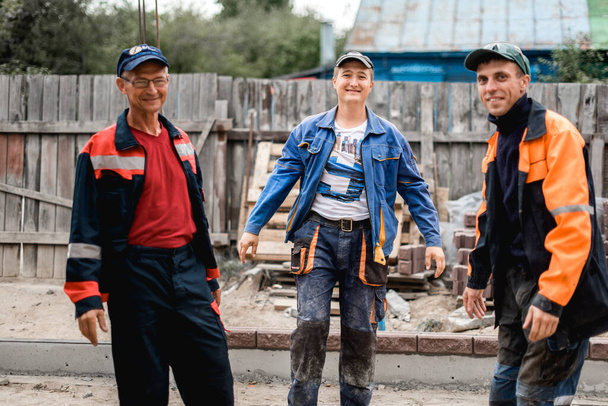 negocio, construcción, trabajo en equipo y concepto de personas - grupo de constructores sonrientes al aire libre
 - Foto, Imagen