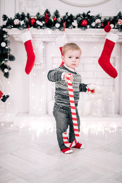 Vánoční portrét mladého chlapce útulná atmosféra kolem krbu a vánoční stromek - Fotografie, Obrázek