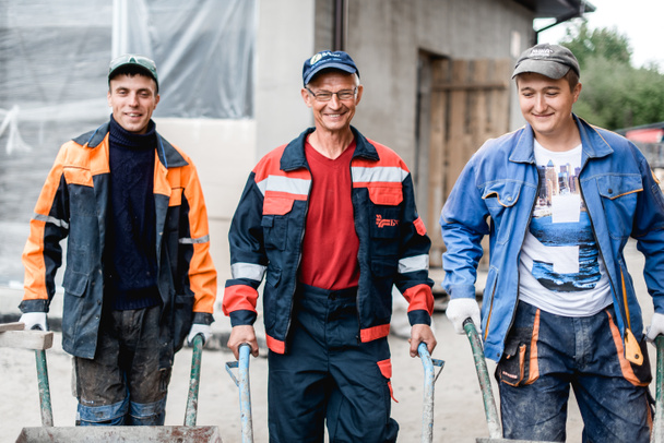 negocio, construcción, trabajo en equipo y concepto de personas - grupo de constructores sonrientes al aire libre
 - Foto, imagen