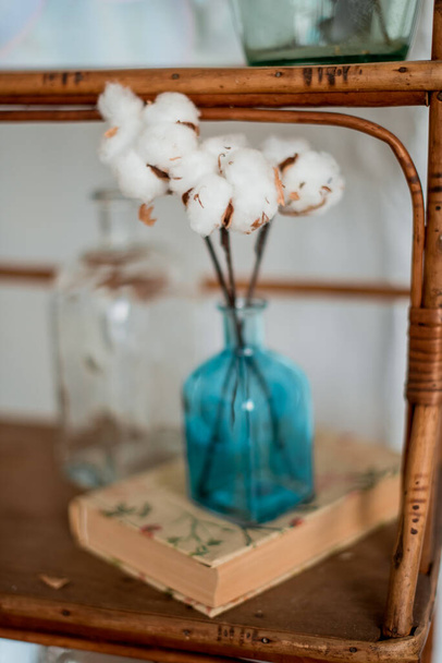 Vaso in vetro blu fiore di cotone da vicino, arredamento casa, interno
 - Foto, immagini