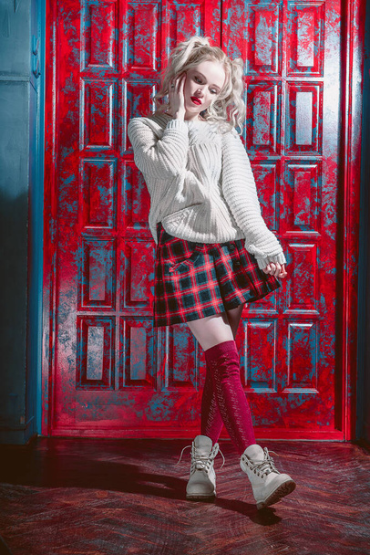 Fashion shot of a blonde girl wearing modern youth clothes. College, school style. Hipster girl wearing glasses by a brick wall. Youth fashion - Photo, Image