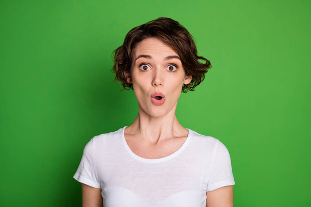 Closeup photo of cute attractive crazy lady wavy bobbed hairdo listen awful news open mouth afraid corona virus disease wear casual white t-shirt isolated bright green color background - Foto, afbeelding
