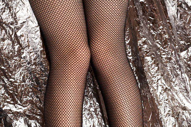 Ağlı tayt içinde güzel kadın bacakları. Borsa tarzı siyah örgü taytlar ve genç bir kızın seksi ayakları.. - Fotoğraf, Görsel