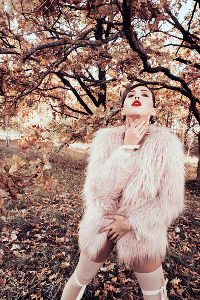 Fashion Female Model In Fashionable Clothes fur coat Posing In autumn forest. Portrét krásné sexy ženy ve stylovém podzimu nebo jarní oblečení: košile, šála, kalhoty, taška sedí na schodech venku na podzim - Fotografie, Obrázek