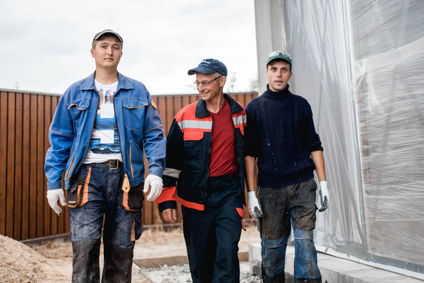 Business, Building, Teamwork und People-Konzept - Gruppe lächelnder Bauarbeiter im Freien - Foto, Bild
