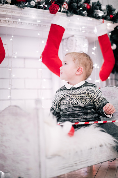 Retrato de Natal de um menino atmosfera acolhedora em torno da lareira e árvore de Natal
 - Foto, Imagem