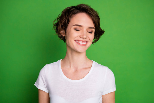 Closeup photo of cute attractive cheerful lady good mood beaming smile wavy bobbed hairdo listen humorous joke laughing wear casual white t-shirt isolated bright green color background - 写真・画像