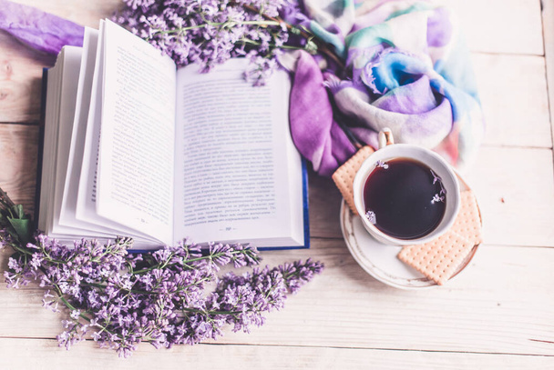 Chávena de chá da manhã, biscoitos e flor lilás na mesa de madeira de cima. Belo pequeno-almoço. Estilo leigo plano com espaço de cópia
 - Foto, Imagem