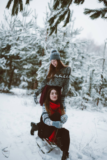 Dos jóvenes adolescentes hipster girl friends together. Acercamiento retrato de moda de dos hermanas abrazos y divertirse tiempo de invierno, el uso de suéter, mejores amigos pareja al aire libre, clima nevado
 - Foto, imagen