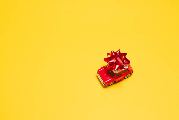 Model machine with a gift on a yellow background - Photo, Image