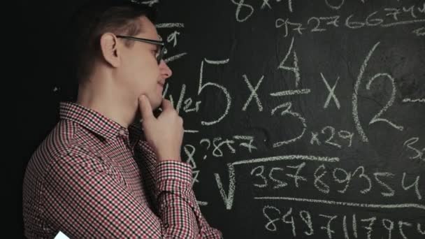 homem escreve fórmula matemática no quadro negro
 - Filmagem, Vídeo