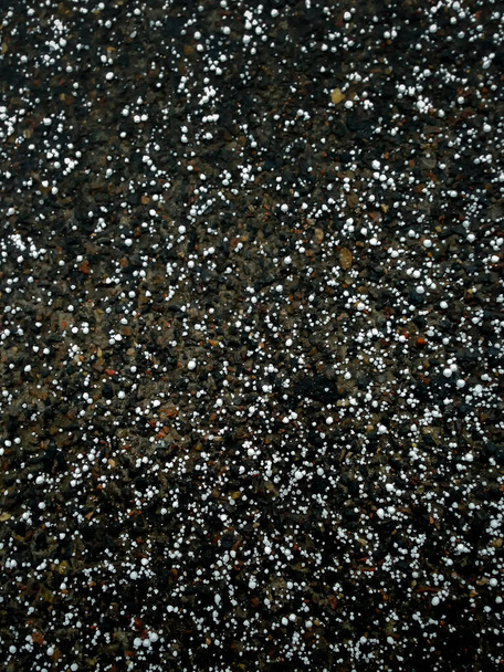 Acaba de caer granizo yace en el camino de asfalto
 - Foto, Imagen