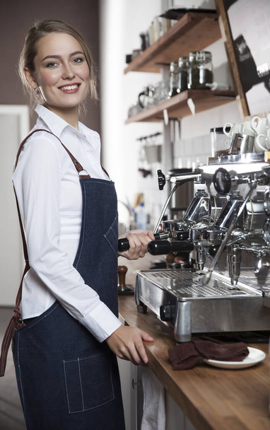  young barista girl makes coffee on a coffee machine - Foto, imagen