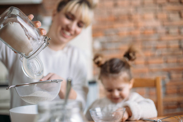 Mother and daughter baking cookies in their kitchen - Foto, Imagen