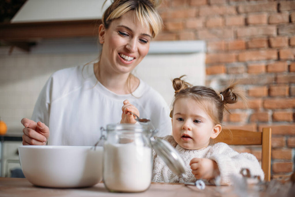 Mother and daughter baking cookies in their kitchen - Valokuva, kuva