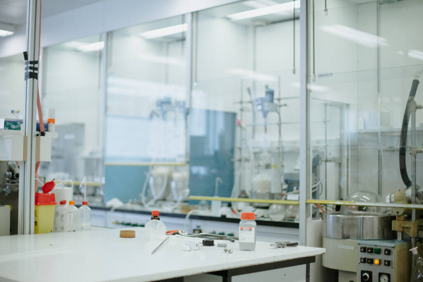 Занятый стол в современной химической лаборатории, подготовленный для исследования коронавирусной вакцины. В лаборатории проводится научный эксперимент
. - Фото, изображение