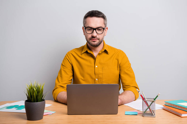 Portrait of focused concetrated intelligent man work home use laptop have online communication with partners colleagues wear yellow shirt isolated over gray color background - Φωτογραφία, εικόνα