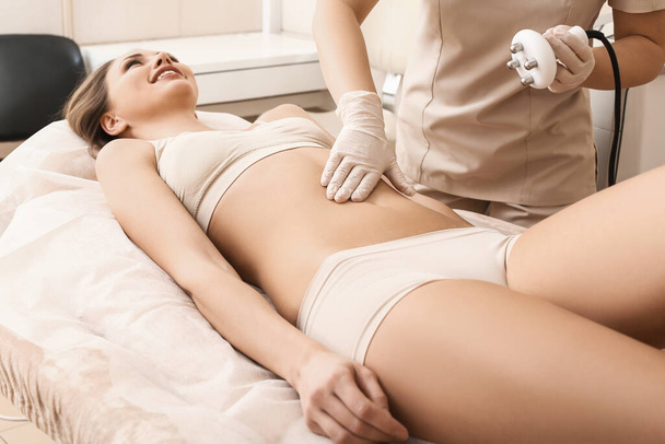 Beautiful woman undergoing procedure of anti-cellulite massage in beauty salon - Fotografie, Obrázek