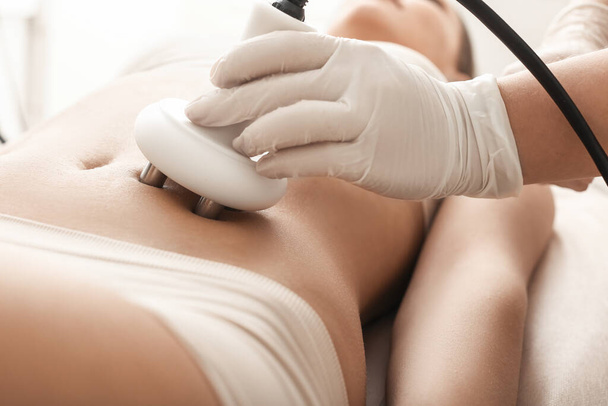 Beautiful woman undergoing procedure of anti-cellulite massage in beauty salon, closeup - Photo, Image