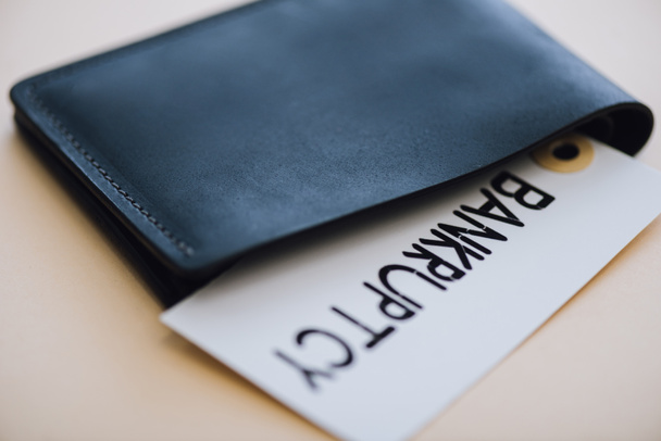 Bolsa preta e cartão com letras de falência em branco
 - Foto, Imagem