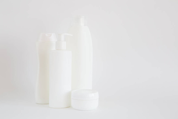 Bottiglie di cosmetici bianchi puliti su uno sfondo bianco. Isolato. Spazio per testo
. - Foto, immagini