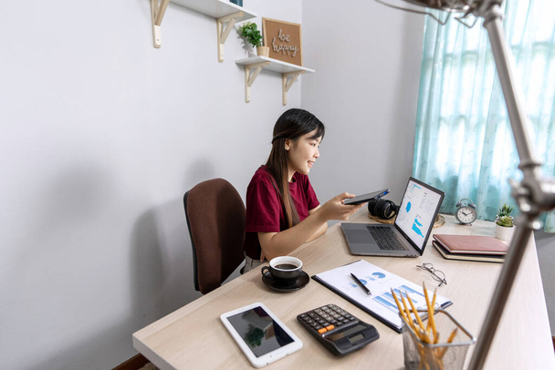Пенсионерка отдыхает на десктопе, работая из дома с ноутбуком для общения в интернете с клиентом, обучается в онлайн-чате, проходит карантин по коронавирусу - Фото, изображение