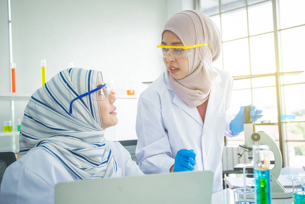 Zwei muslimische Chemikerinnen beim Experiment im Labor. - Foto, Bild