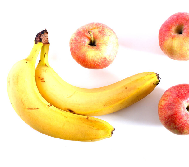 punaisia omenoita ja banaaneja valkoisella pohjalla. Vitamiinit hedelmät
. - Valokuva, kuva