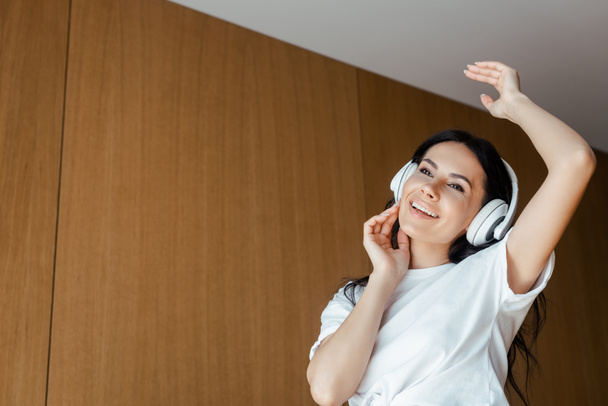 beautiful happy girl dancing and listening music with headphones at home - Photo, Image
