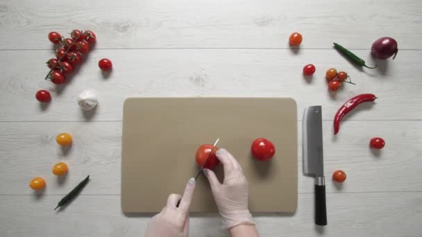 シェフはプラスチックボード上のトマトをカットトップビュー - 映像、動画