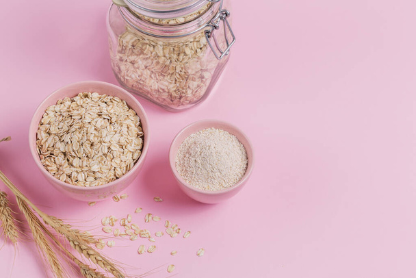 Ingredients for making homemade facial mask or scrub. Bowl of dry oat flakes with oatmeal and ears of wheat  - Fotoğraf, Görsel