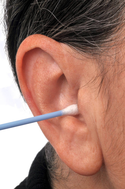Nő tisztítja a fülét egy pamut tamponnal  - Fotó, kép